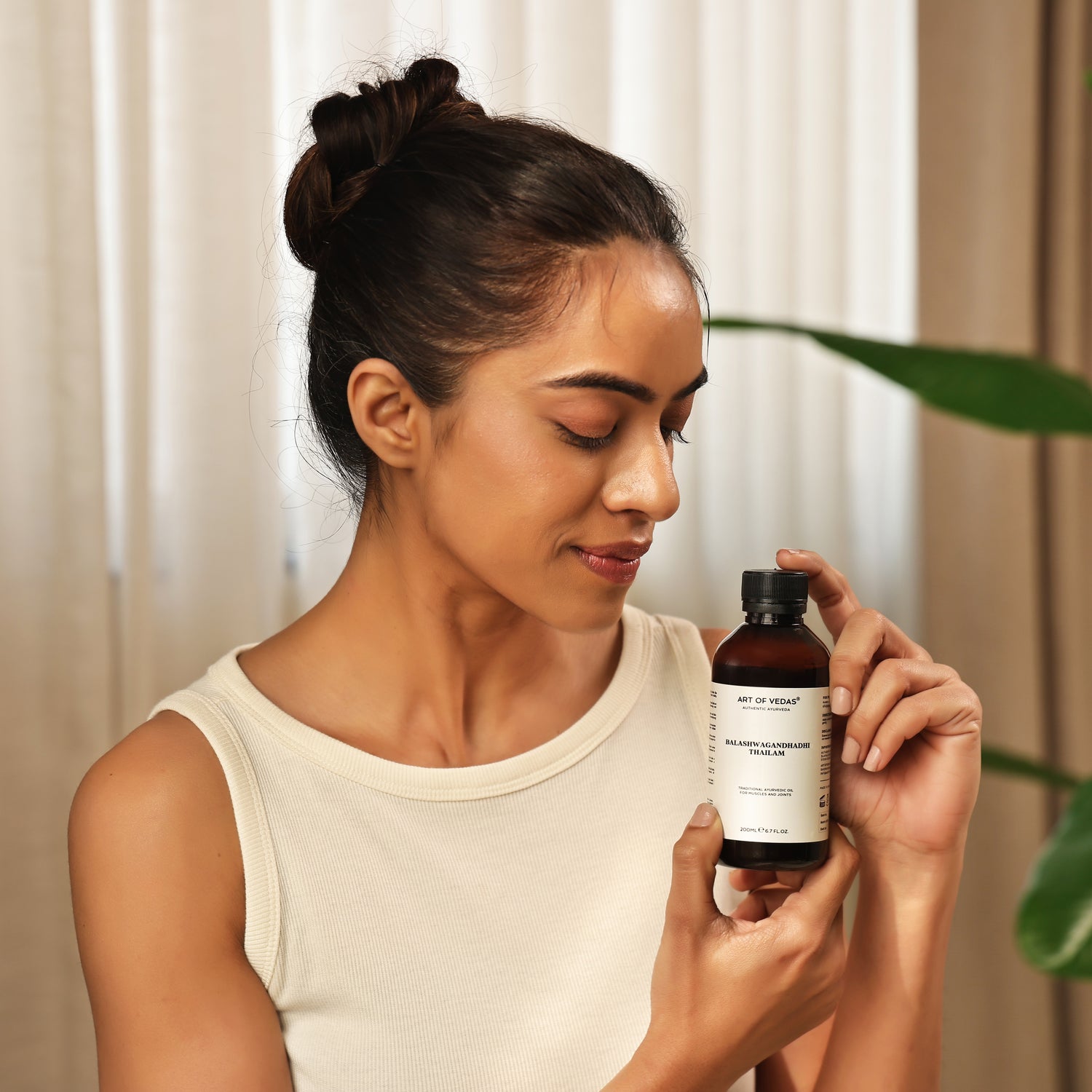 Art of Vedas Balaswagandhadhi Thailam - Woman Holding Ayurvedic Strengthening Oil for Body Nourishment and Vitality